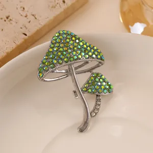 Close-up detail of silver mushroom brooch featuring iridescent green pavé rhinestones