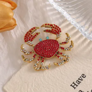 Detailed view of an alloy crab brooch inlaid with sparkling red and clear rhinestones.