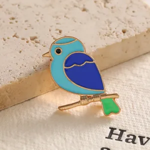 Close-up of a colorful blue bird enamel brooch with golden finish details