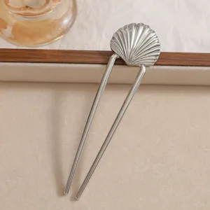 Detailed view of a silver seashell U-shaped hair fork with elegant texture.