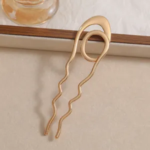 Detailed view of elegant gold U-shaped hairpin with hammered wavy texture design