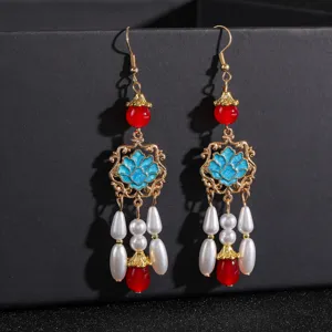 Gros plan de boucles d'oreilles chinoises vintage à pompons avec perles et motif de lotus.