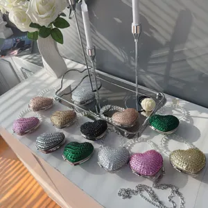 Variety of shimmering heart-shaped rhinestone mini bags displayed with elegant props