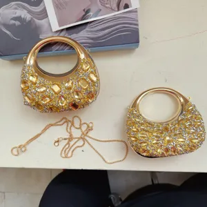 Close-up of luxury mini evening clutch bags with sparkling yellow rhinestones and gold chain.