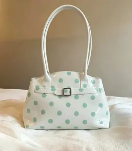 Borsa a tracolla in vernice bianca con pois verdi e cinturino decorativo con fibbia