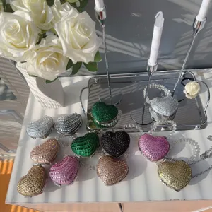 Detailed view of luxury heart-shaped rhinestone mini bags in various colors with chains