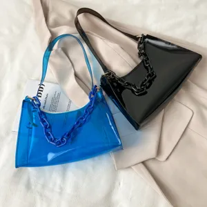 Detail view of blue transparent and black glossy underarm bags with chunky chains