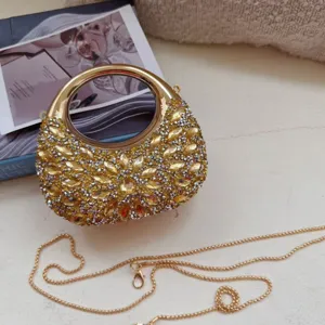 Detailed view of a mini rhinestone evening bag with a golden circular handle and chain.