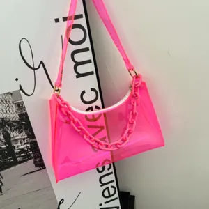 Detail of a vibrant neon pink transparent PVC underarm jelly bag with matching chunky chain strap