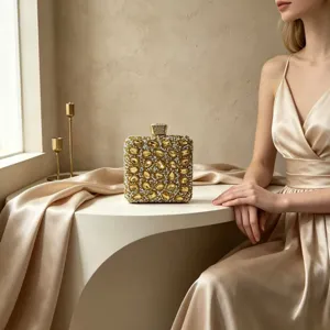 Gold crystal-encrusted evening clutch bag shown in a luxury banquet lifestyle setting.