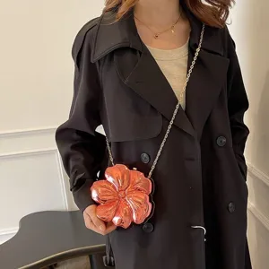 Detailed view of a metallic rose gold acrylic flower shaped evening clutch bag