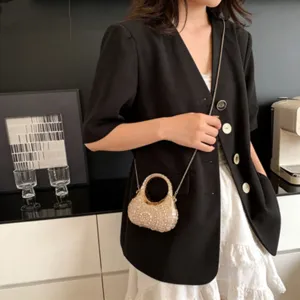 Bolso de noche mini de lujo con pedrería y cadena dorada en una modelo asiática