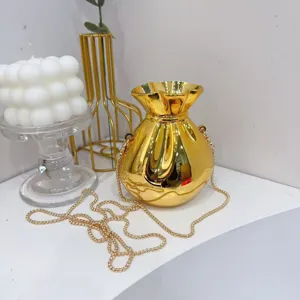 Close-up of a luxury gold acrylic evening clutch bag with a sleek metallic chain