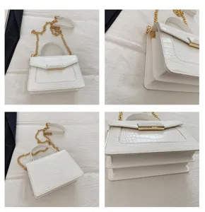 Vista detallada de bolso blanco en PVC con textura de cocodrilo y cadena dorada.