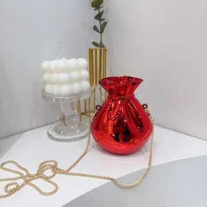 Detail shot of a glossy red metallic fortune bag evening clutch with gold chain