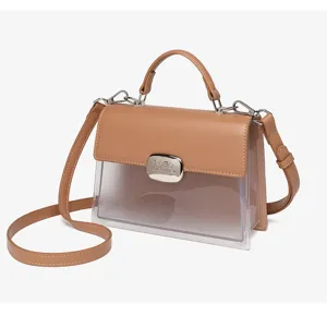 Detailansicht der braunen Leder- und transparenten PVC-Handtasche mit silbernem Verschluss.