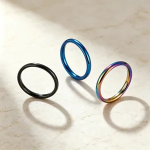 Gros plan détaillé de bagues minimalistes et fines en acier titane en plusieurs coloris.
