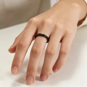 Bague fine minimaliste noire en acier titane incurvée de 2mm, détail de bijoux élégants.