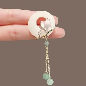 Detailed view of Neo-Chinese jade ring brooch with magnolia flower and green tassels