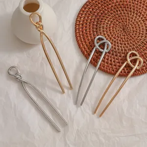 Épingles à cheveux en forme de U dorées et argentées avec un design de nœud élégant.