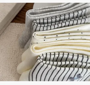 Close-up view of folded cotton socks featuring striped and polka dot patterns with soft texture.