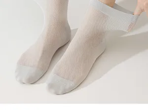 Gros plan de chaussettes d'été fines et respirantes pour hommes en maille gris clair.