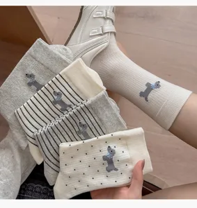 Detail view of women's mid-tube cotton socks featuring cute puppy embroidery, striped and polka dot patterns.