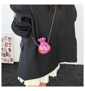 Detailed macro view of the pink metallic fortune-shaped evening bag with a gold chain strap