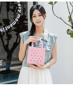 Asian model holding a pink waterproof PVC beach bag with stylish hole design details