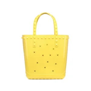 Vibrant yellow PVC jelly tote bag with star cutouts and studded handles for beach