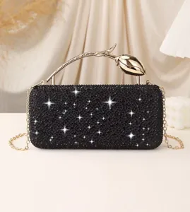 Close-up of elegant black rhinestone evening clutch bag featuring a gold rose handle