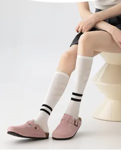 Detail shot of white athletic calf socks with black stripes and breathable mesh patterns.