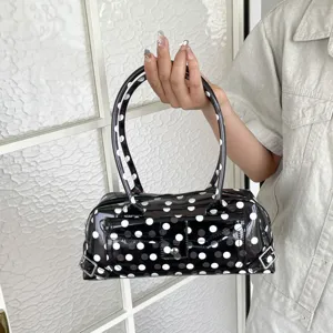 Detailed view of black and white polka dot PVC jelly underarm bag with glossy finish