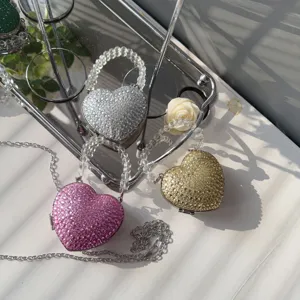 Detail of mini heart-shaped evening bags with shimmering rhinestones and bead handles.