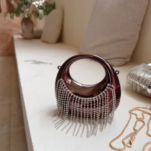 Luxuriöse metallische Abendtasche in Halbmondform mit glitzernden Strassfransen.