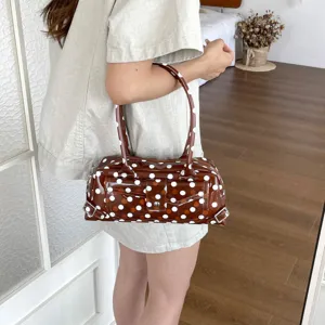 Trendy brown PVC shoulder bag featuring white polka dots and a glossy jelly finish.