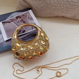 Detailed view of luxury gold moon bag with crystals and yellow rhinestones