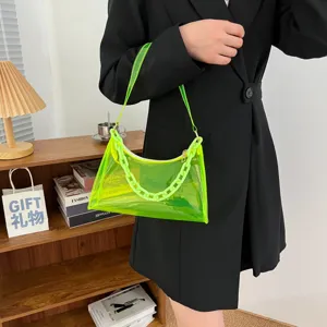 Detail view of a neon green transparent PVC baguette bag featuring a chunky chain strap