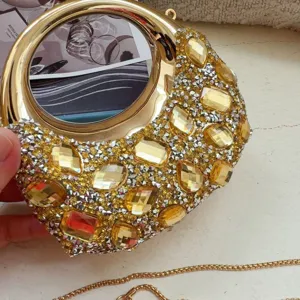 Detailed view of the sparkling yellow crystals and silver rhinestones on the gold crescent bag