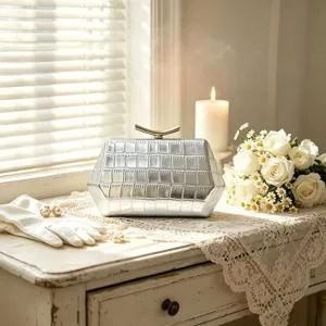 Close-up of silver hexagonal crocodile pattern clutch bag in romantic setting