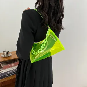 Detail shot of a model wearing a neon green transparent PVC jelly bag with a plastic chain.