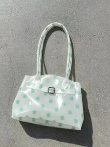 Vista dettagliata del motivo a pois verde menta su una borsa jelly in PVC bianco traslucido