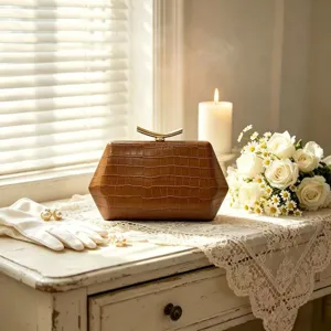 Detail of brown hexagonal crocodile pattern evening clutch on a lace table with flowers.