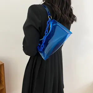 Stylish blue transparent PVC underarm bag with thick chain strap worn on black dress