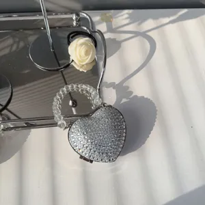 Detailed view of elegant heart-shaped rhinestone mini evening bag with beaded handle