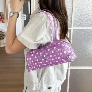 Close-up of a stylish purple polka dot PVC jelly shoulder bag worn on the model's shoulder