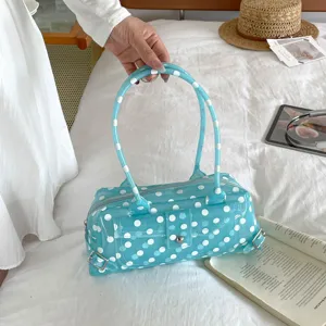 Detailed view of a stylish light blue polka dot PVC jelly handbag in a lifestyle setting.