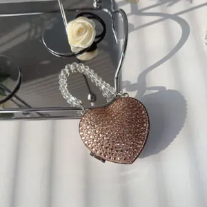 Detailed view of luxury heart-shaped rhinestone mini bag with elegant beaded handle