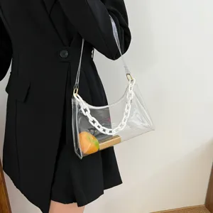 Minimalist clear PVC underarm bag featuring a chunky white chain strap on model arm.
