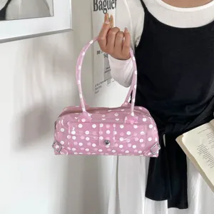 Pink polka dot PVC jelly bag held by a model in a chic lifestyle setting